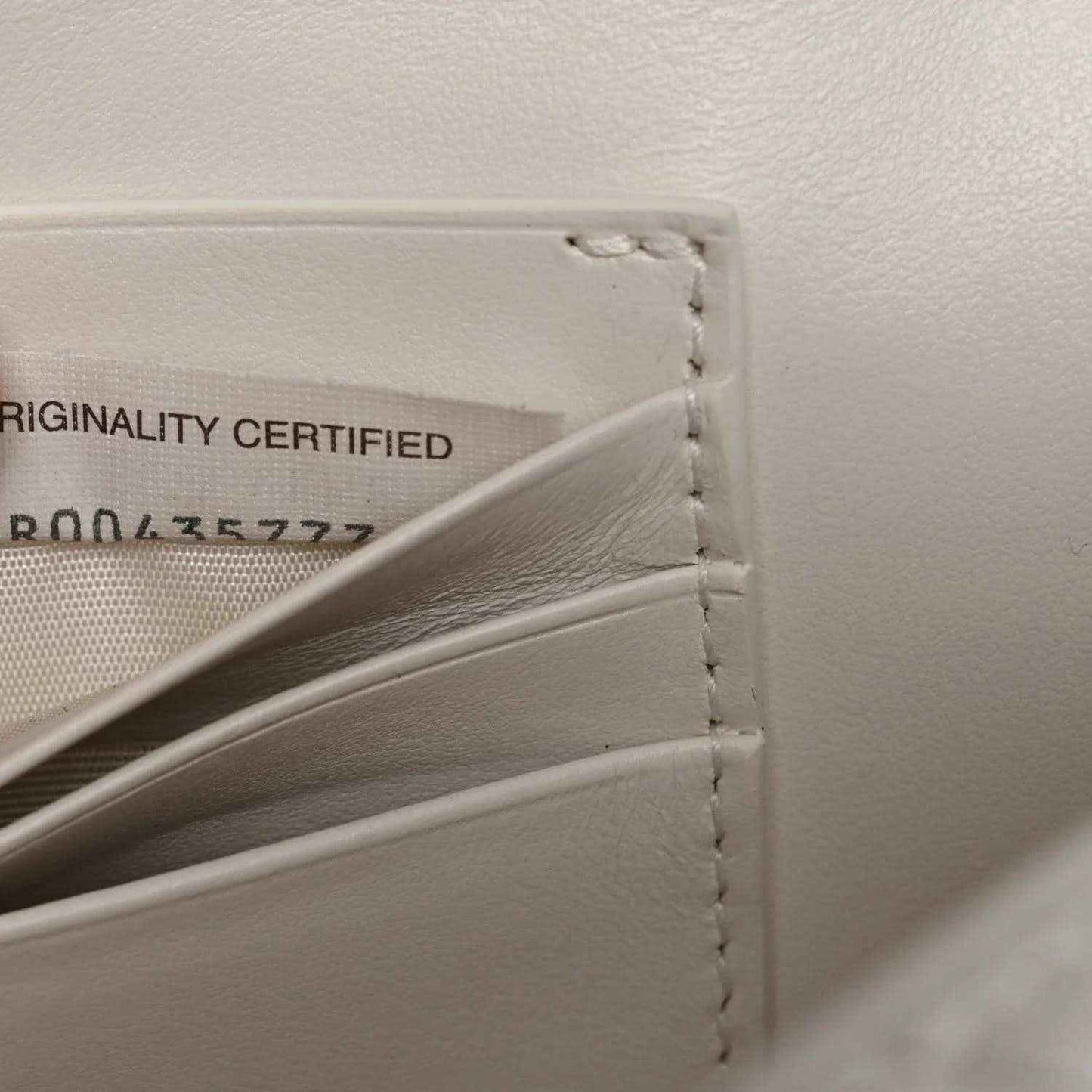 White leather clutch interior with originality label and side stitching