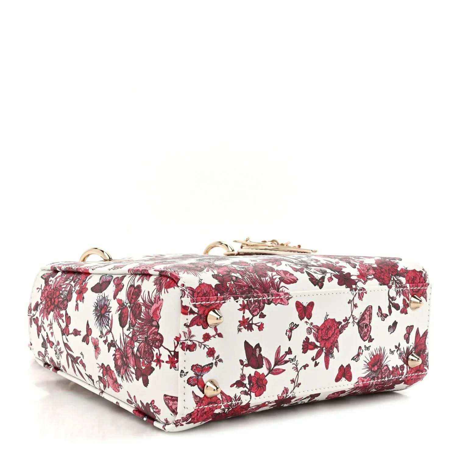 White and red floral handbag with top handle and structured flap front, gold-tone details