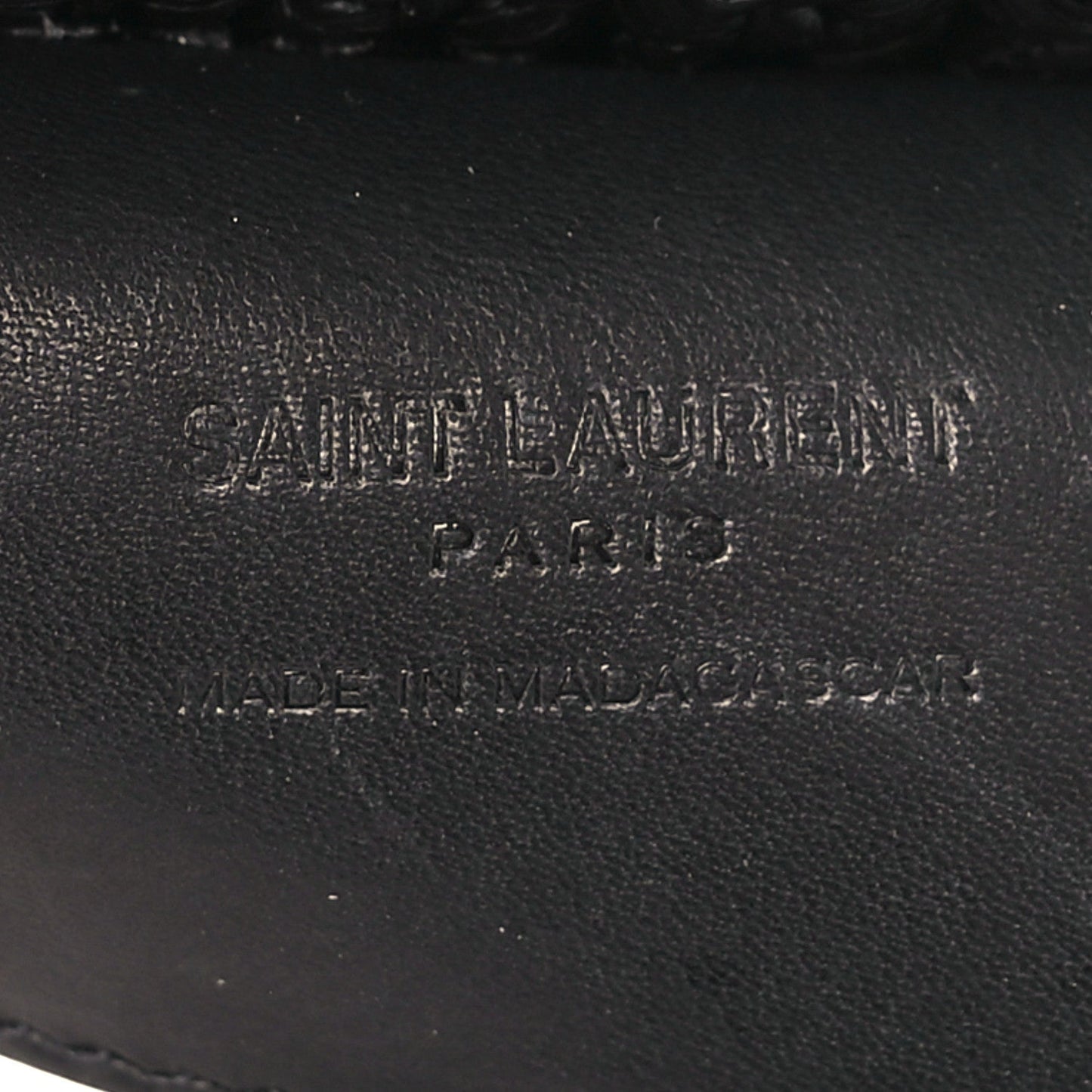 Black leather interior label with stamped text on shoulder bag