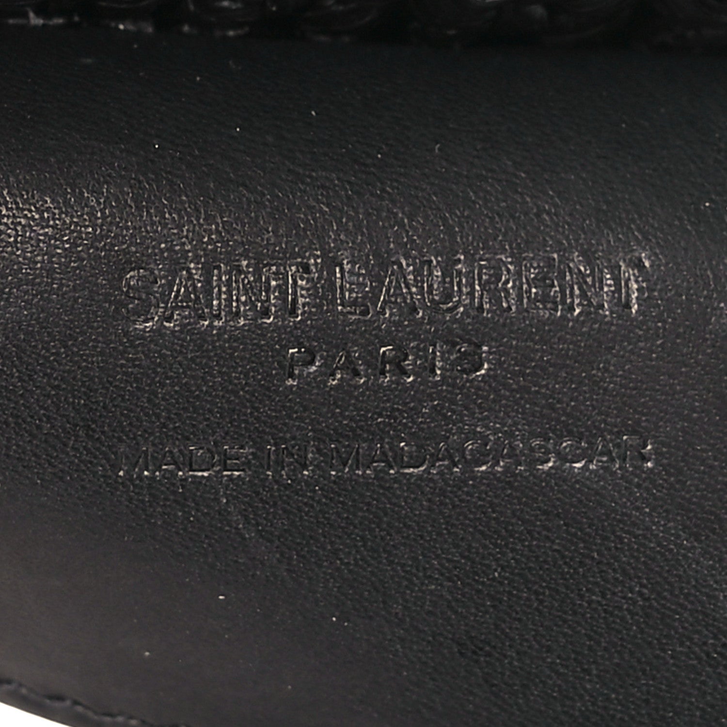 Black leather interior label with stamped text on shoulder bag