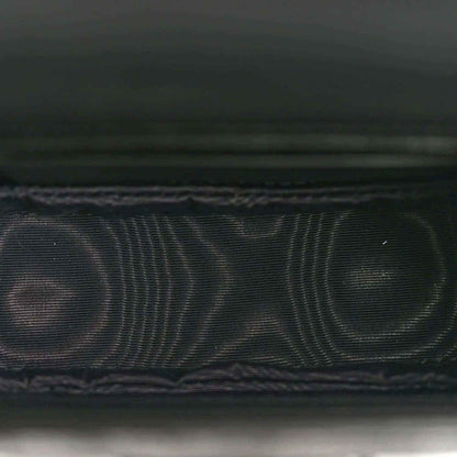 Black embossed leather detail with fine grid texture and stitched edge
