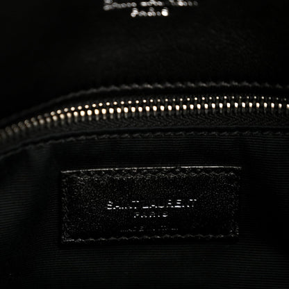 Black interior pocket of quilted lambskin satchel with zipper at top edge