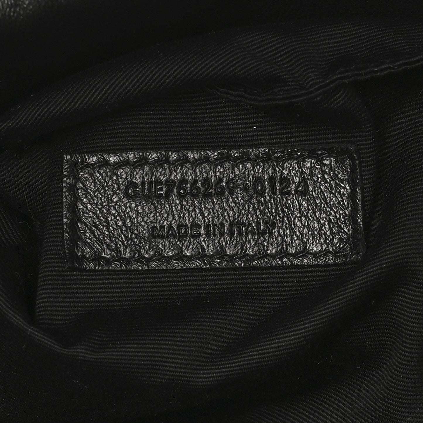 Black leather tote interior care label with model code and Made in Italy text.