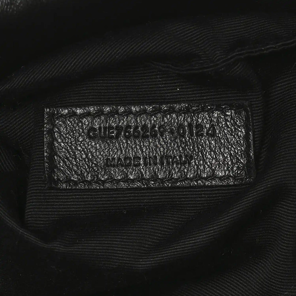 Black leather tote interior care label with model code and Made in Italy text.