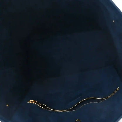 Dark interior of monogram tote bag with gold chain zipper pull