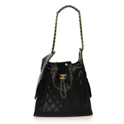 Black Chanel drawstring bucket handbag with chain strap, tassels, and gold CC logo