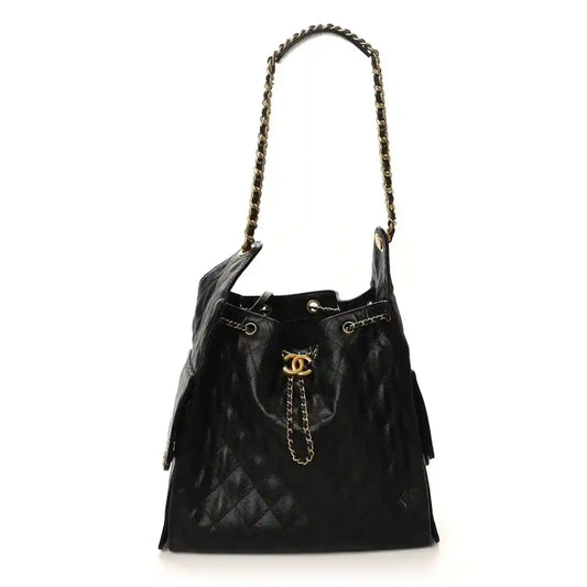 Black Chanel drawstring bucket handbag with chain strap, tassels, and gold CC logo