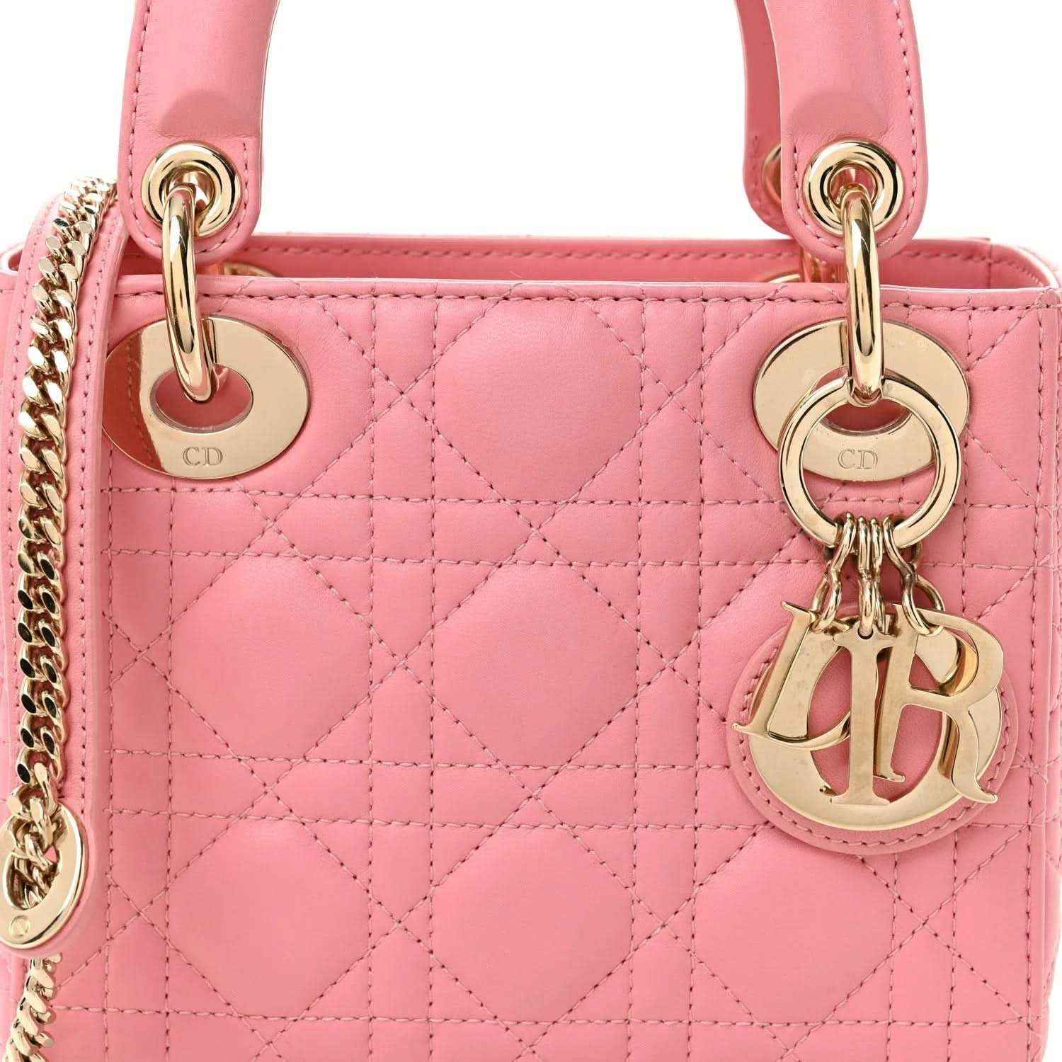 Light pink quilted mini handbag front with handles, chain, and gold Dior charm