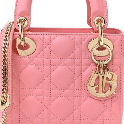 Light pink quilted mini handbag front with handles, chain, and gold Dior charm