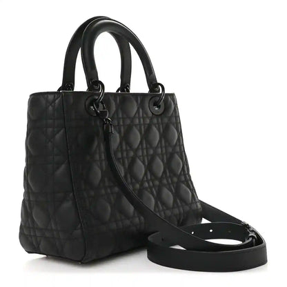 Black quilted Lady Dior bag with top handles and long shoulder strap, angled view