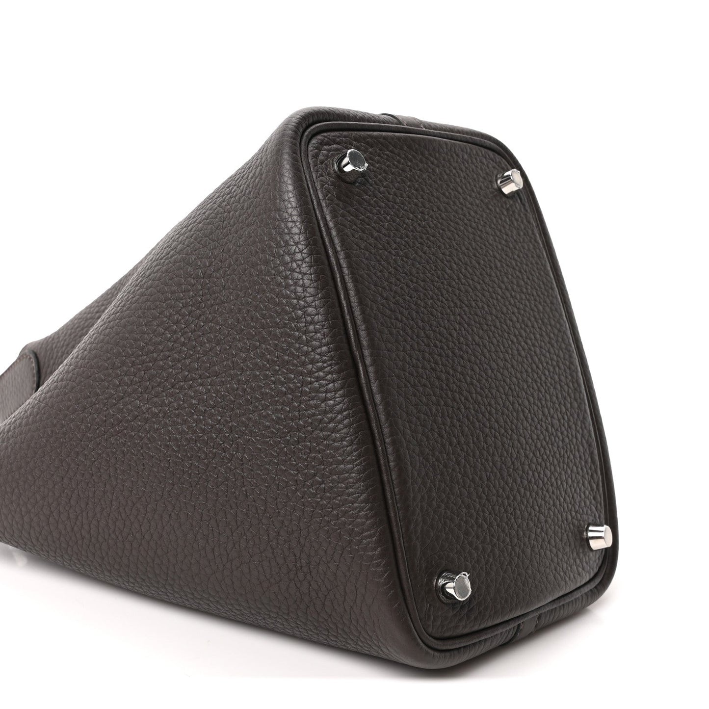 Dark brown leather tote bag corner detail with metal feet and lock hardware