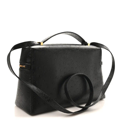 Black ostrich leather satchel with front zipper, wide strap, and gold-tone accents.
