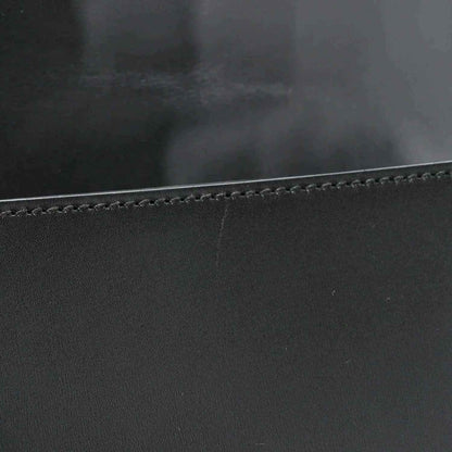 Black leather messenger bag edge with contrast stitching and smooth calfskin texture