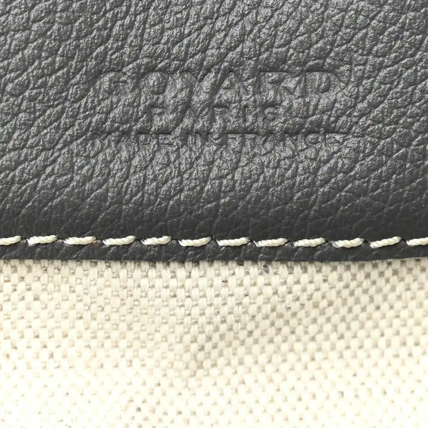 Grey leather trim and textured surface on hobo bag with white edge stitching