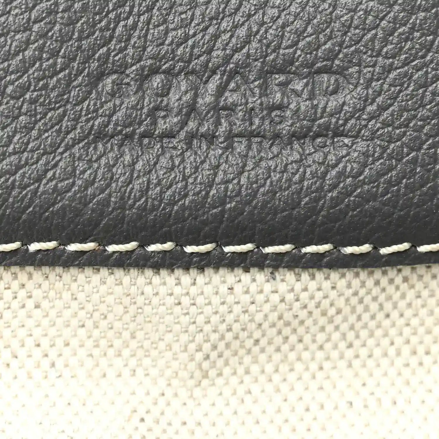 Grey leather trim and textured surface on hobo bag with white edge stitching