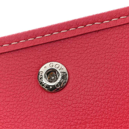 Fuchsia leather strap detail with round Goyard logo snap and topstitched edge