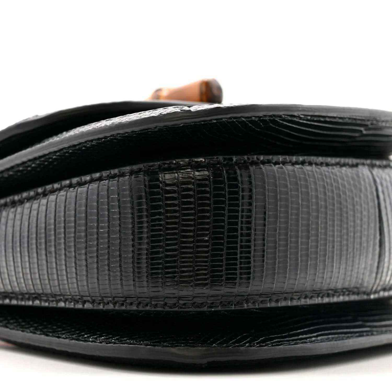 Top edge close-up of black mini bag with glossy trim and embossed texture