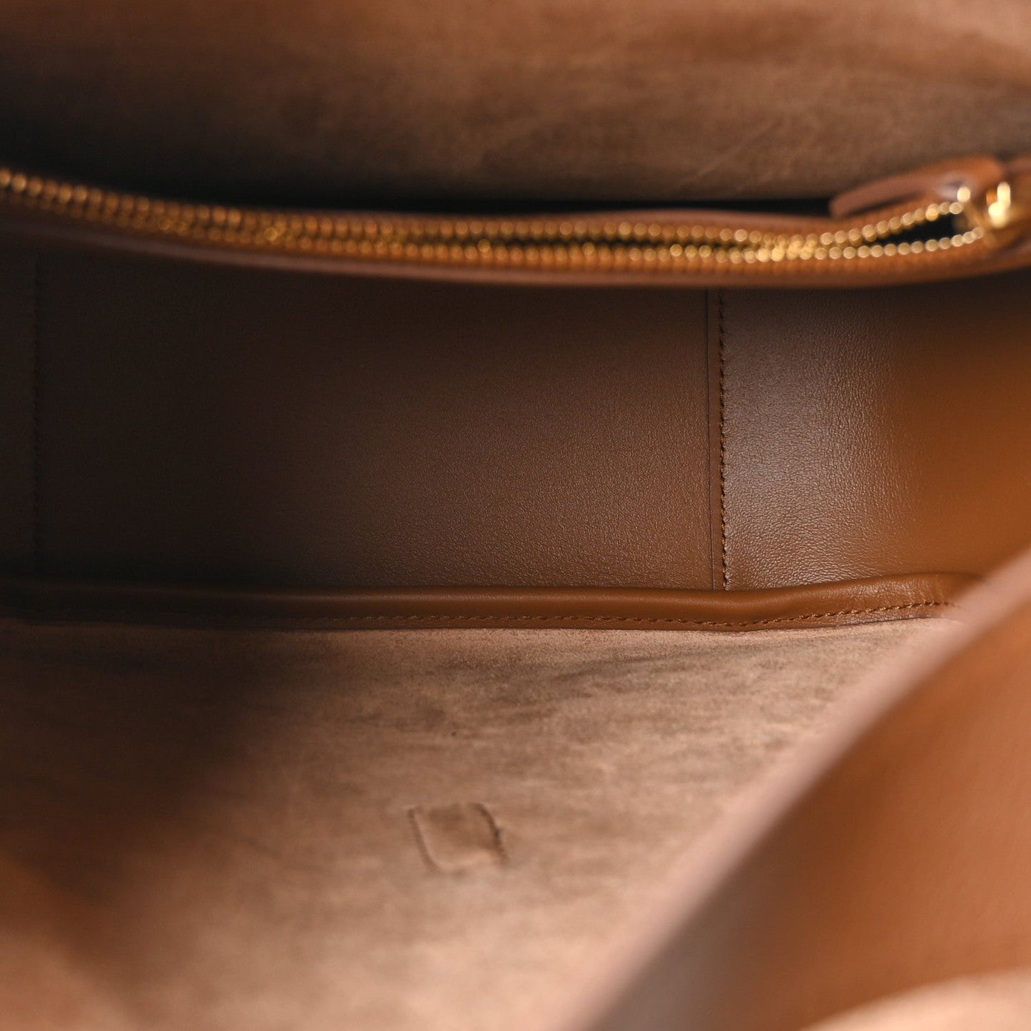 Hobo bag interior with gold-tone zipper and stitched leather panel