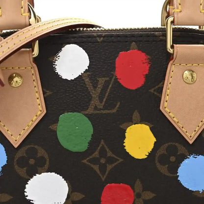 Handbag exterior with black monogram base and colorful dot appliques, tan trim.