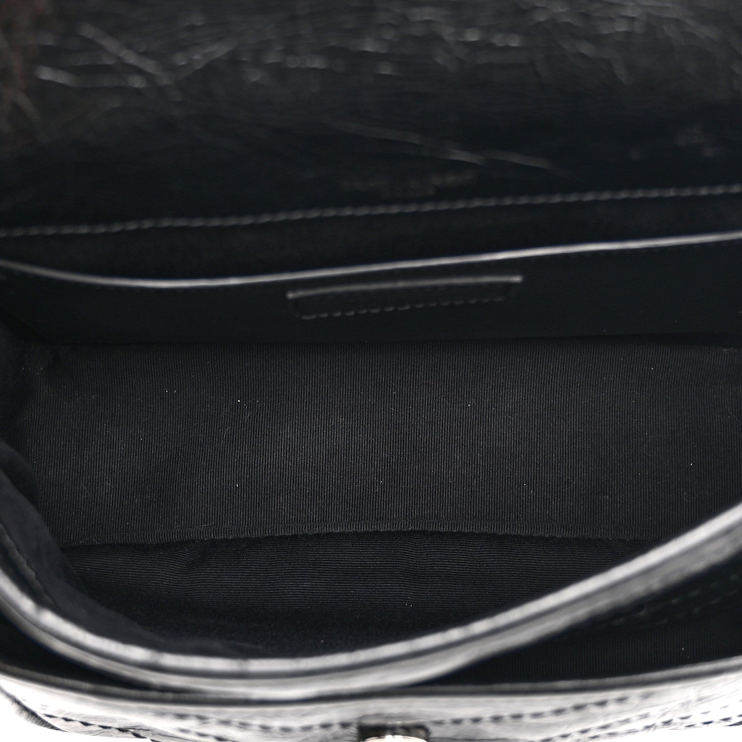 Black satchel interior with fabric lining and stitched edge detail