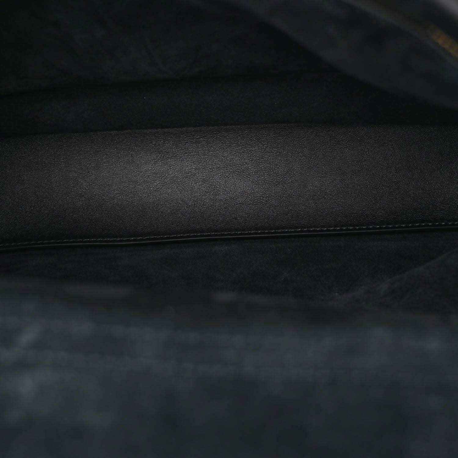 Black leather interior panel with stitched edge and smooth grain texture.
