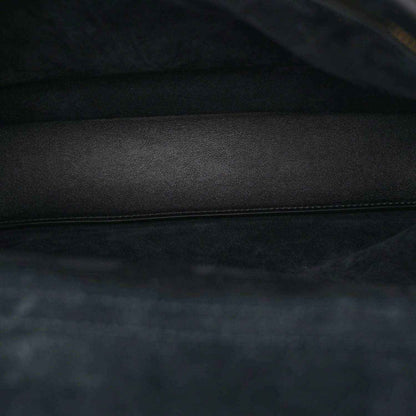 Black leather interior panel with stitched edge and smooth grain texture.
