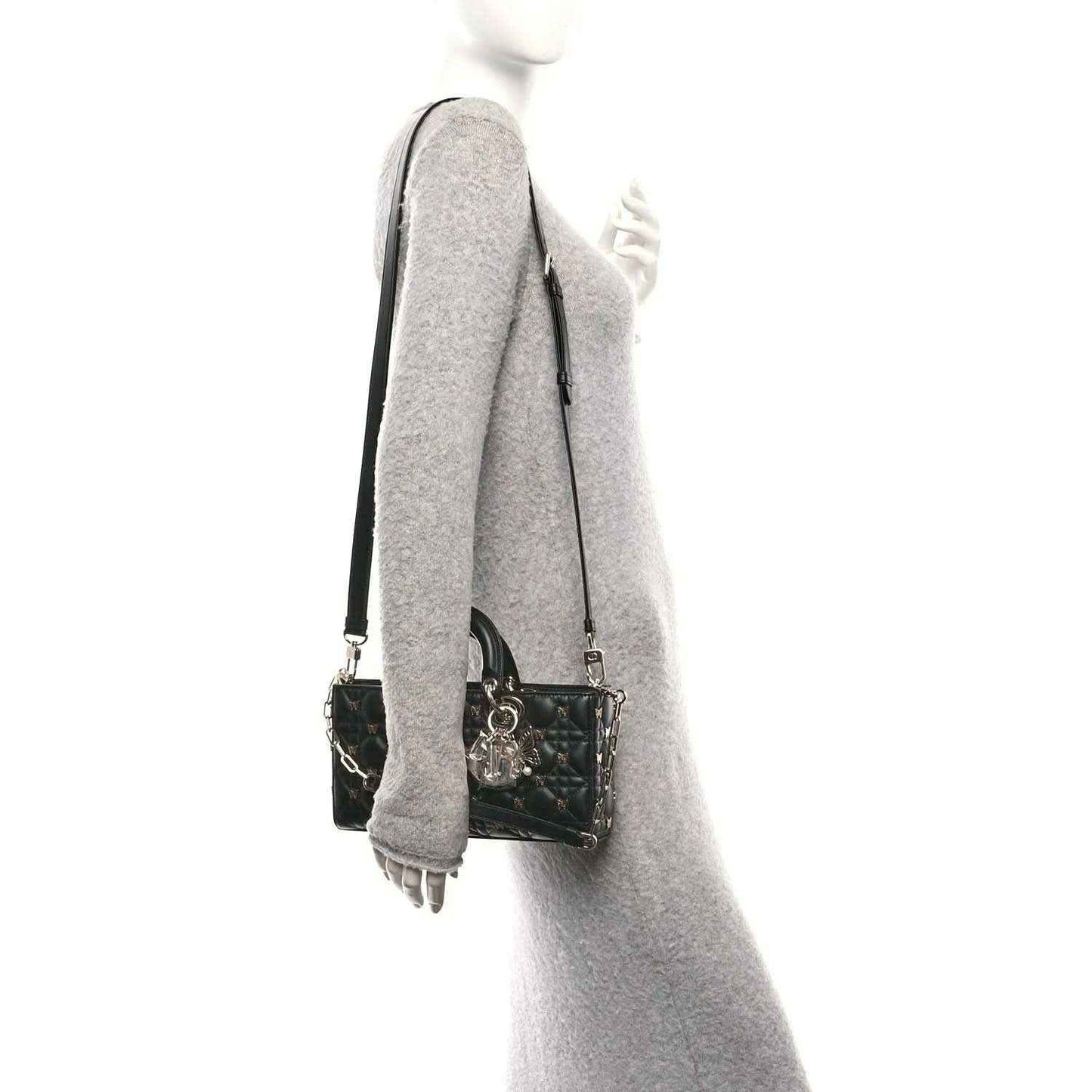 Black quilted handbag with chain-and-leather shoulder strap hanging at side