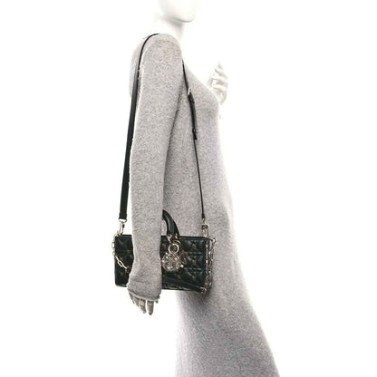 Black quilted handbag with chain-and-leather shoulder strap hanging at side