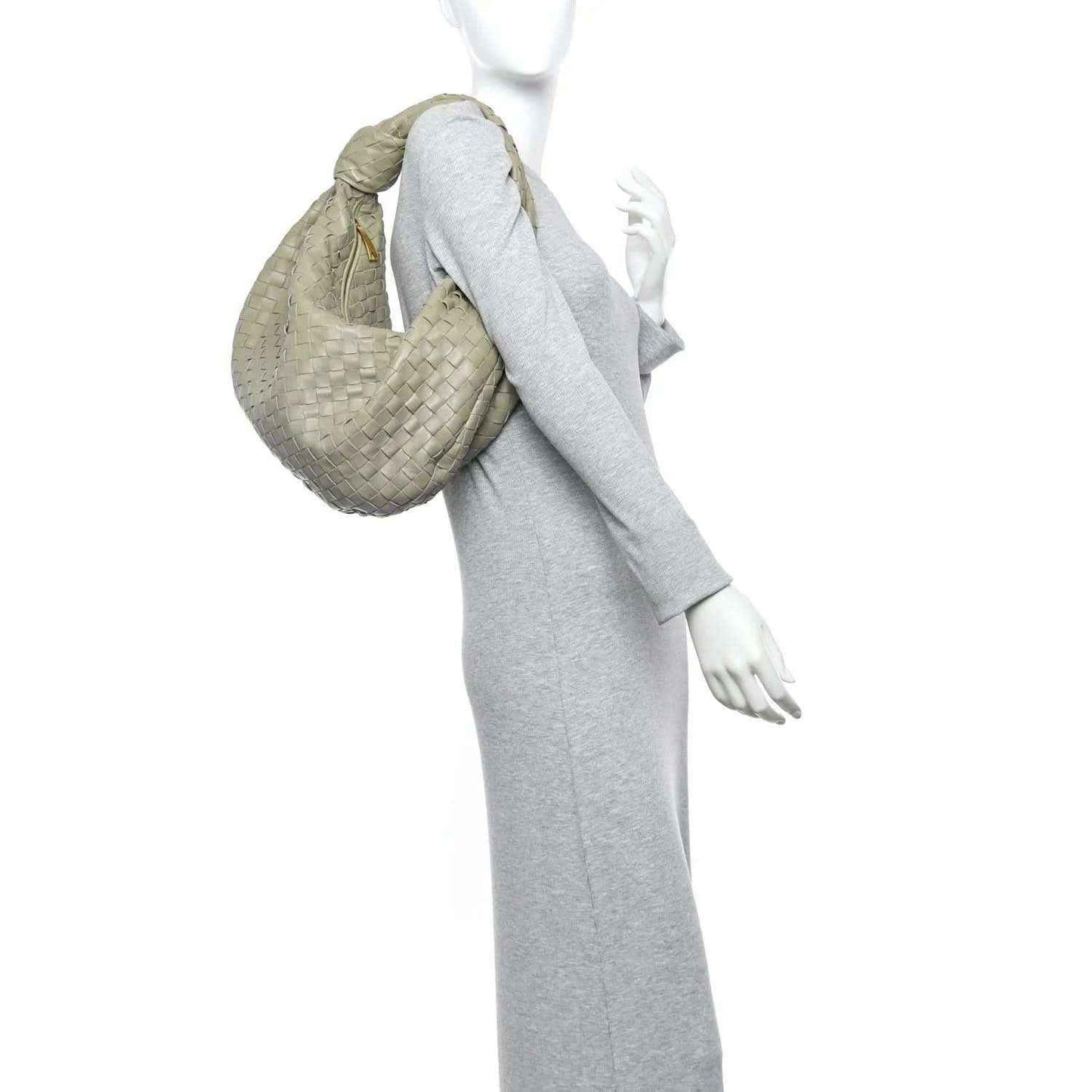 Small woven leather hobo bag held by model, travertine light taupe color