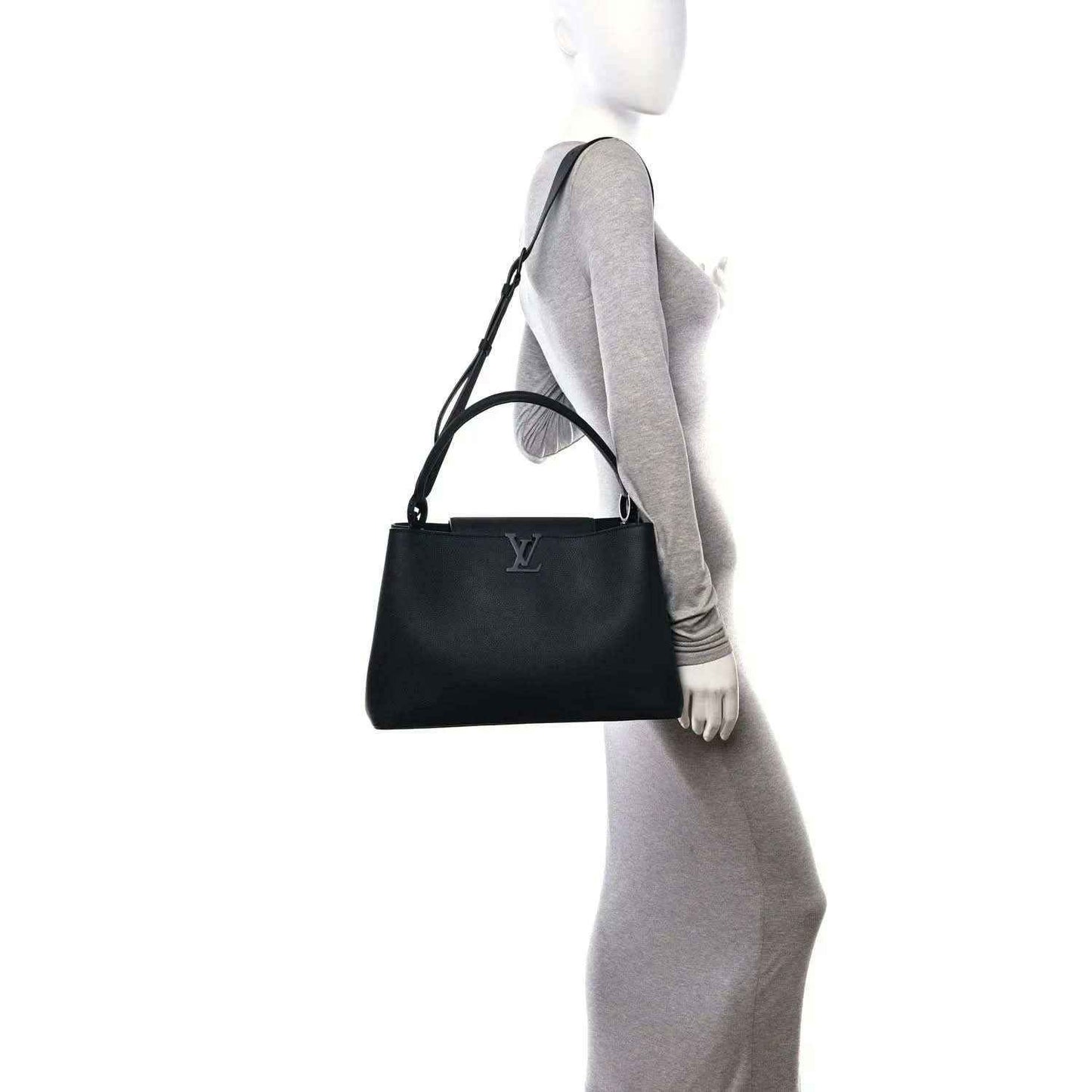 Black matte leather handbag worn at side with adjustable shoulder strap