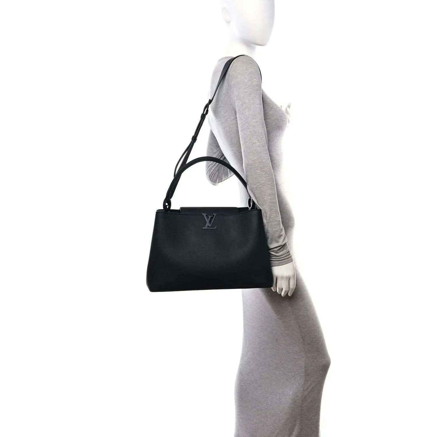 Black matte leather handbag worn at side with adjustable shoulder strap