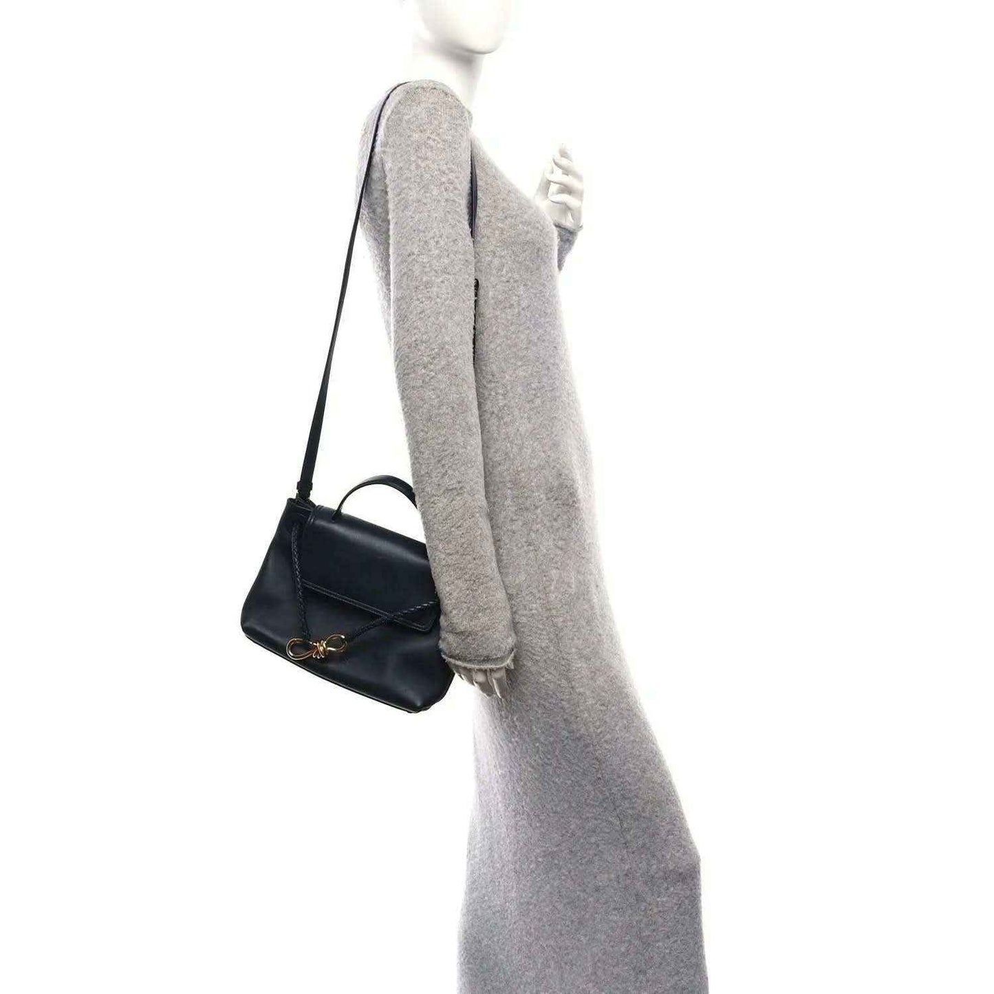 Black small handbag with shoulder strap and gold-tone clasp, side view