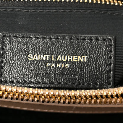 Black leather label with SAINT LAURENT PARIS text and gold zipper