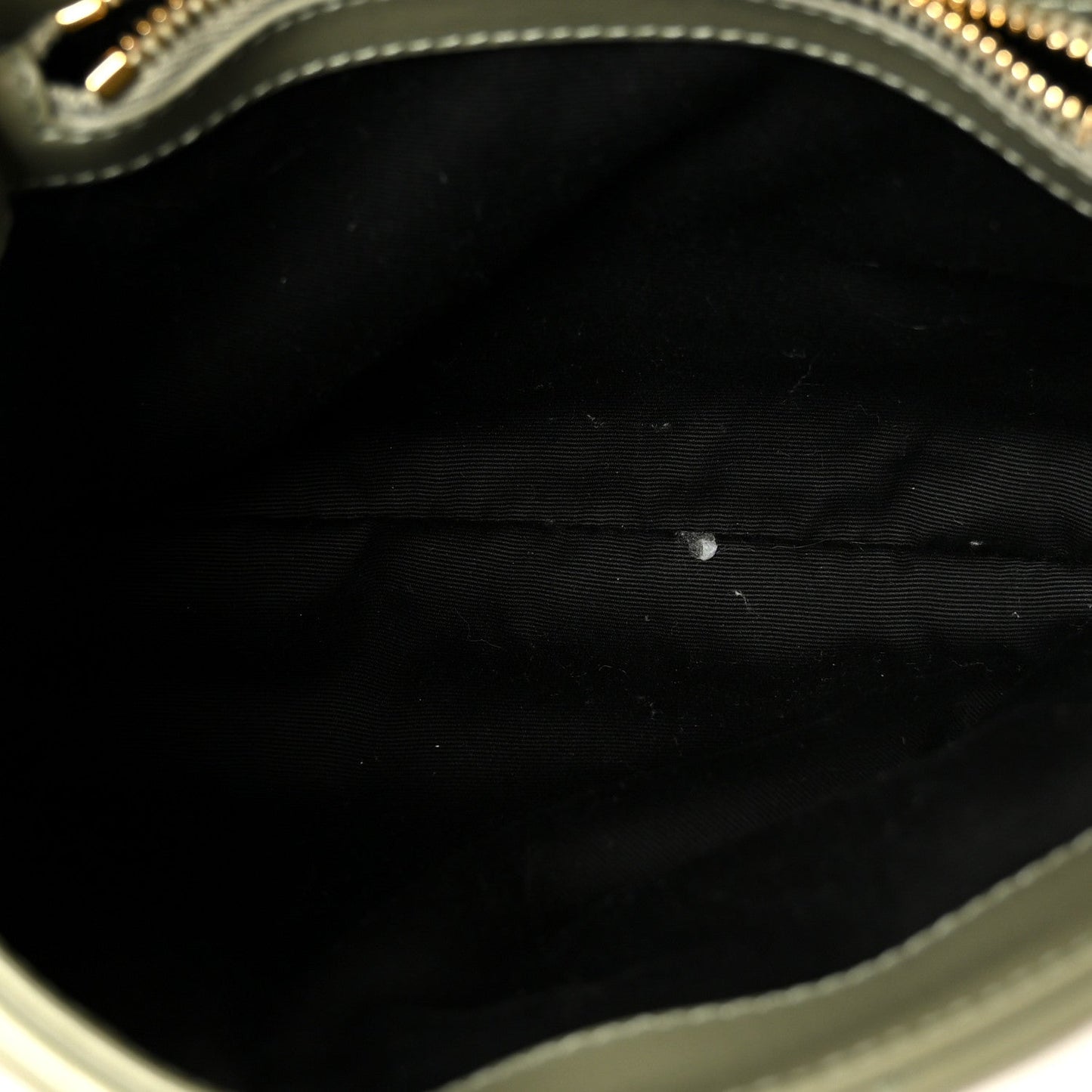 Black fabric lining inside a light sage small chain satchel with zipper trim