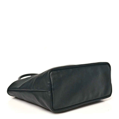 Black reversible mini tote bag with carry handles and structured top edge.