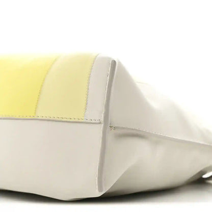 Close-up of pale grey and light citrine panels with curved front seam on clutch