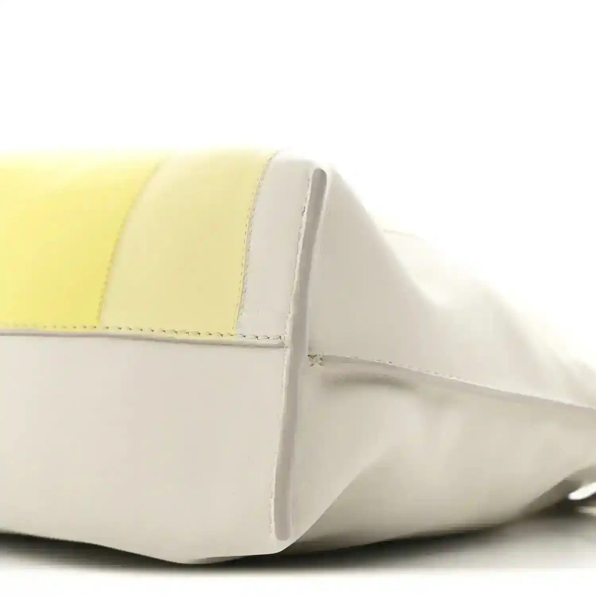 Close-up of pale grey and light citrine panels with curved front seam on clutch