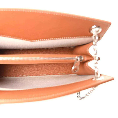 Close-up of mini tote bag hardware: tan leather edge trim and silver chain with clasp.