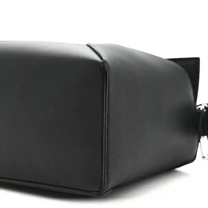 Small black calfskin shoulder bag with structured panels and top handle