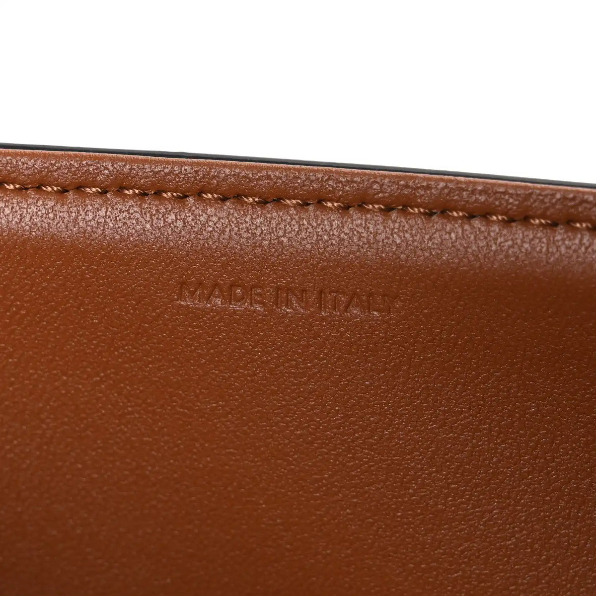 Tan leather edge with “MADE IN ITALY” stamped text and stitched border.