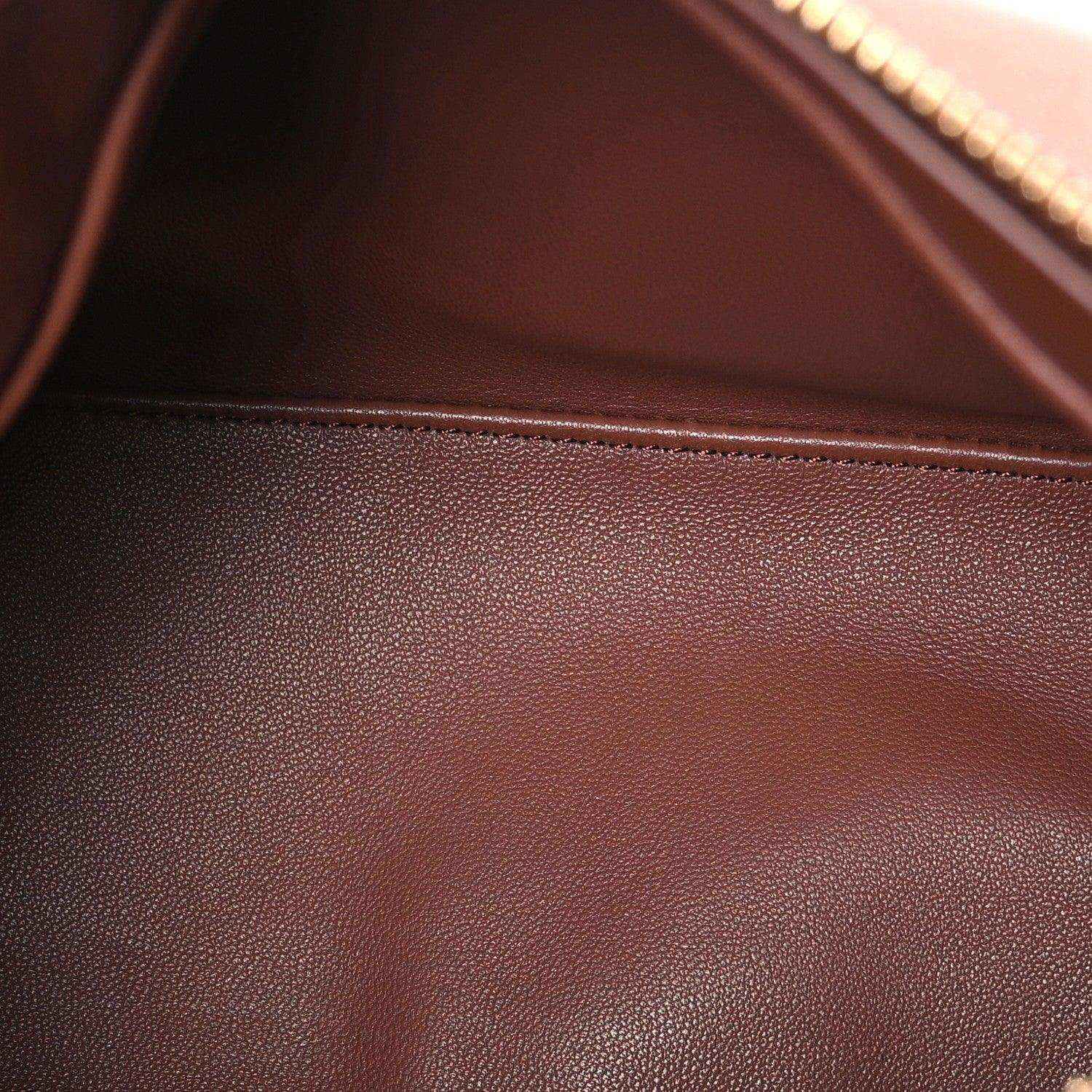 Pecan brown leather bag surface with fine grain texture and visible interior seam