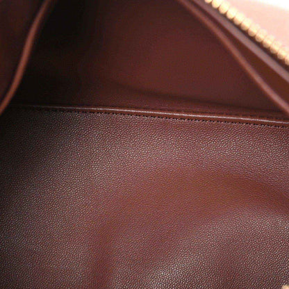 Pecan brown leather bag surface with fine grain texture and visible interior seam