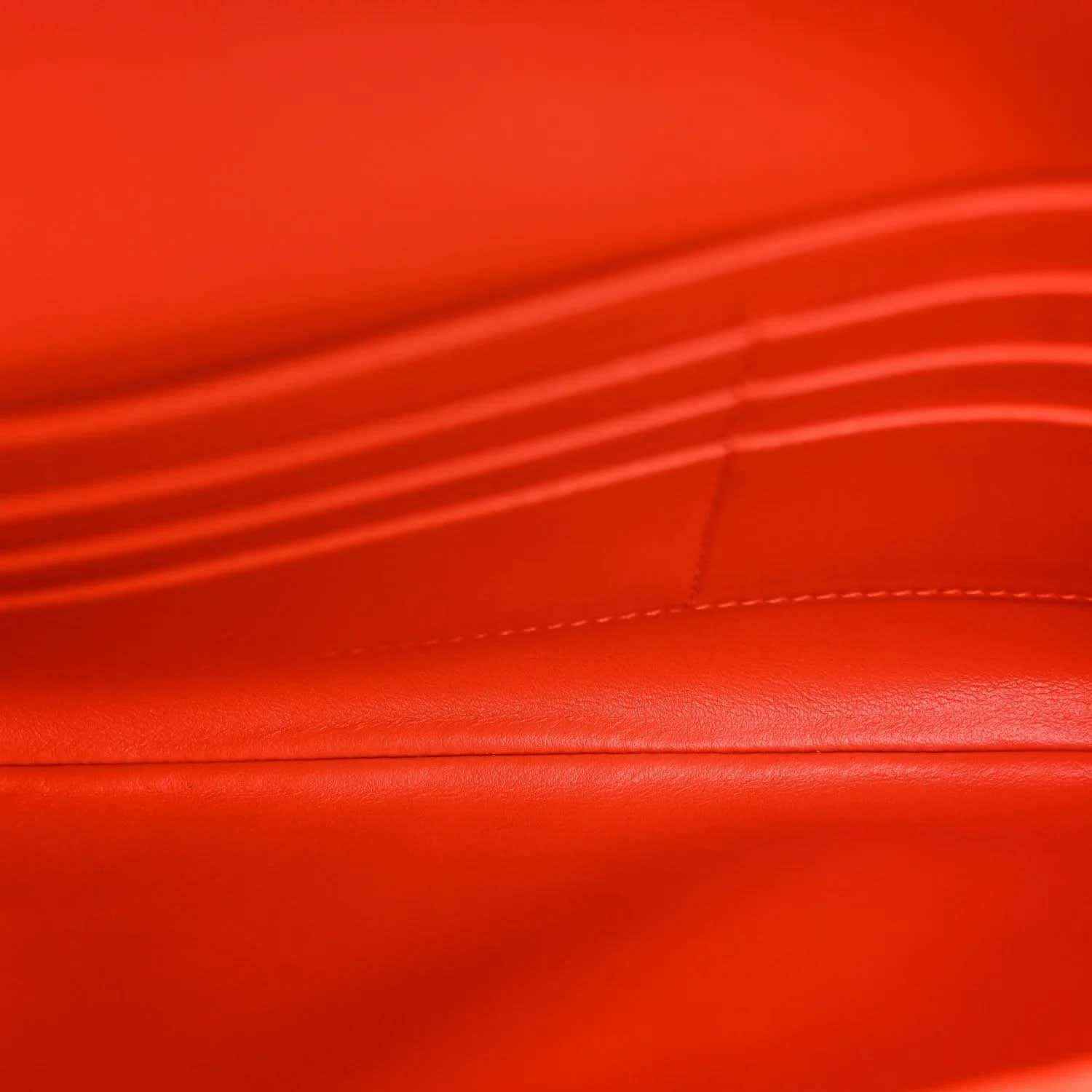 Orange nappa clutch leather close-up with stitched panel and woven edge detail