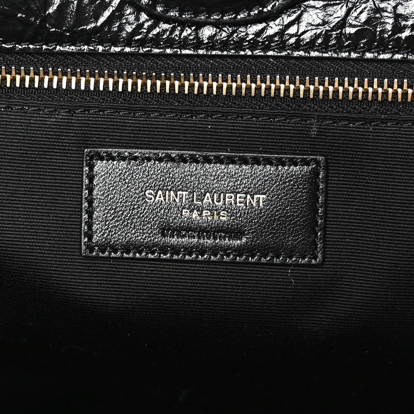 Black leather interior label with SAINT LAURENT PARIS text and gold zipper