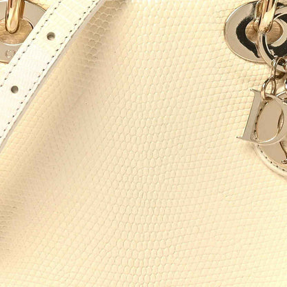 Ivory lizard mini handbag close-up with gold D charm and leather texture