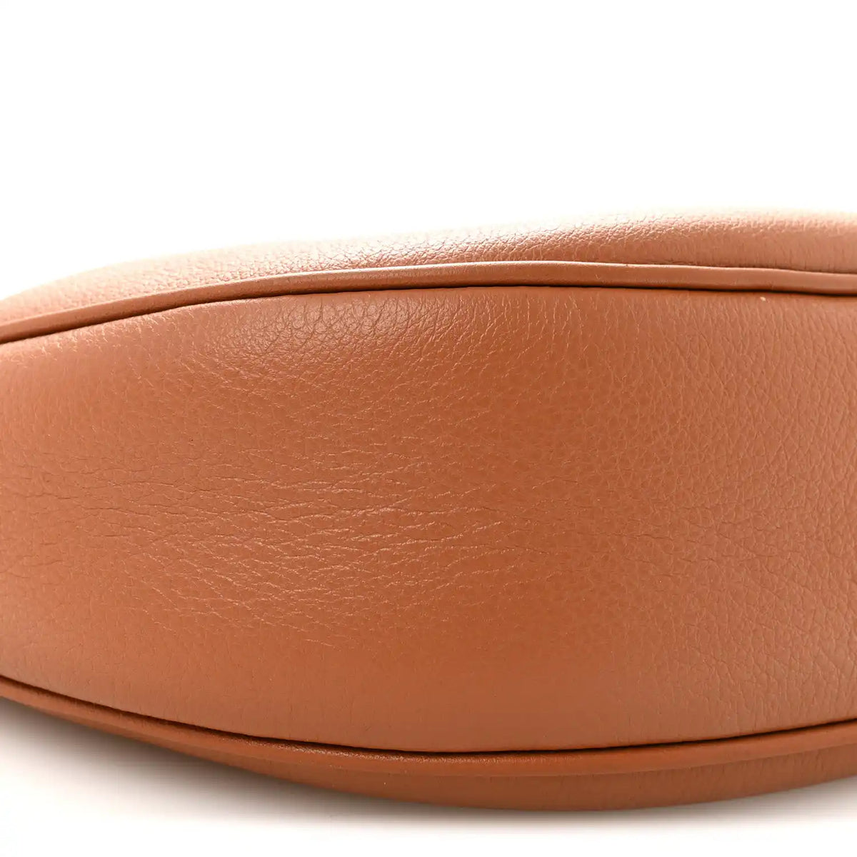 Tan leather hobo bag front panel close-up with smooth grain and curved seam