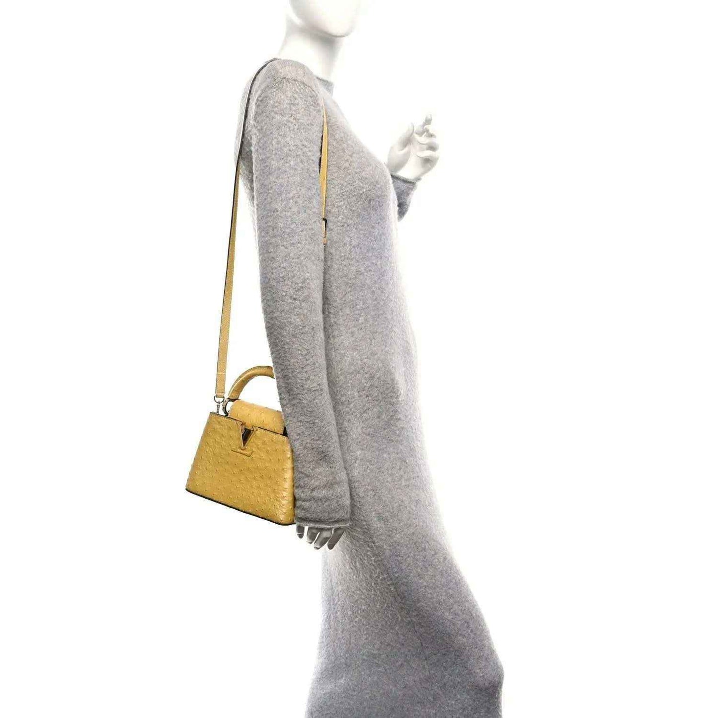 Yellow mini top-handle bag worn on shoulder, side view with single strap