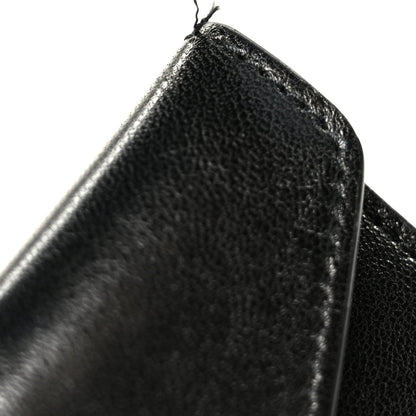 Black lambskin shoulder bag edge close-up with textured grain