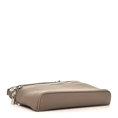 Mini leather pouch with top zipper and rounded base, viewed from side