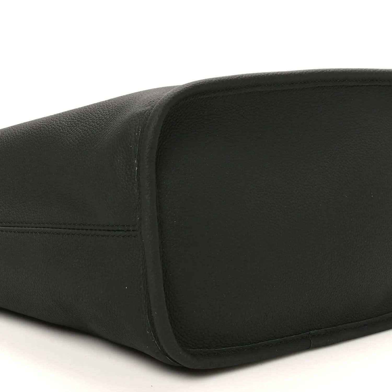 Black pebbled leather tote with rounded bottom edge and visible stitching